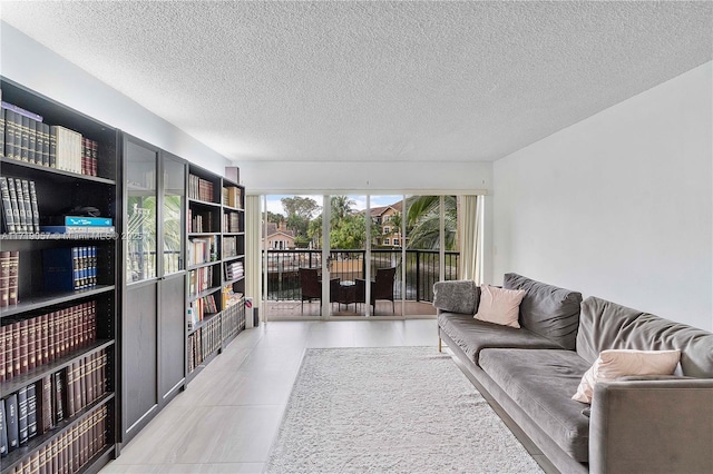 tiled living room featuring a textured ceiling