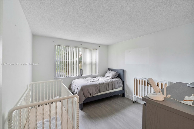 bedroom featuring a textured ceiling and hardwood / wood-style flooring