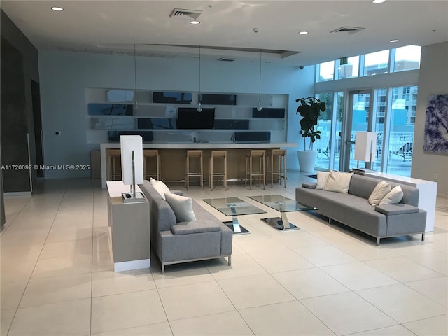 living room featuring light tile patterned floors and a high ceiling