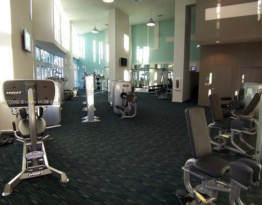 gym with a towering ceiling and carpet floors