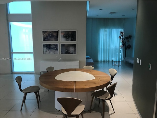 tiled dining space featuring a healthy amount of sunlight