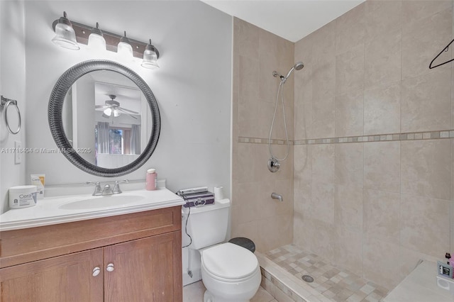 bathroom with toilet, a tile shower, ceiling fan, and vanity