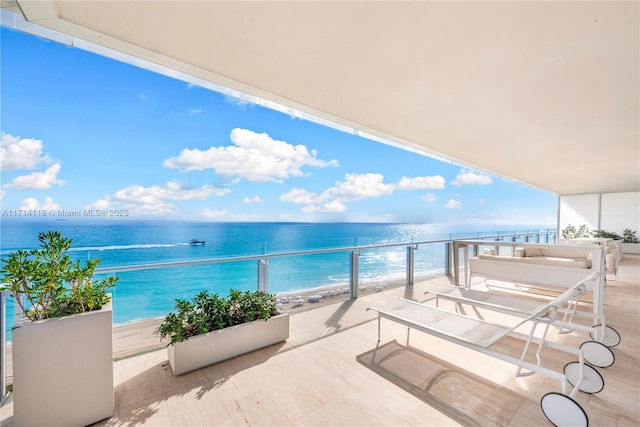 balcony featuring a water view and a beach view