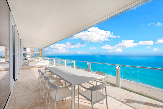 balcony featuring a water view and a beach view