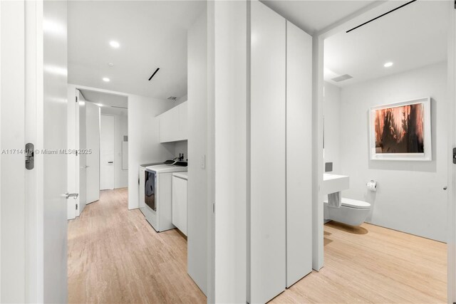 interior space with light wood-type flooring and washer and clothes dryer