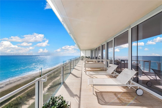 balcony featuring a water view and a view of the beach