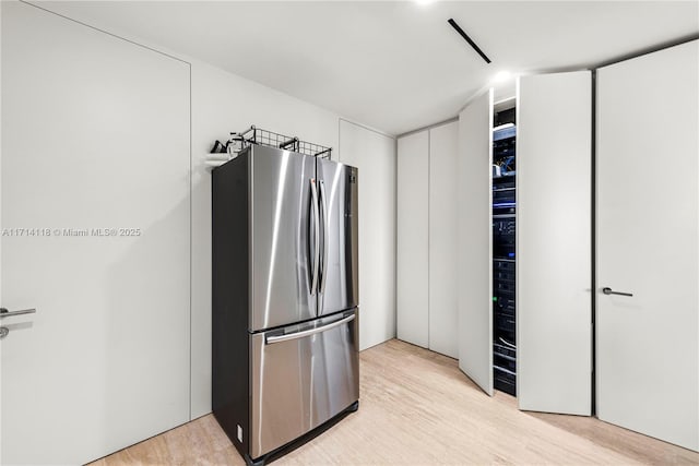 kitchen with stainless steel fridge and light hardwood / wood-style floors