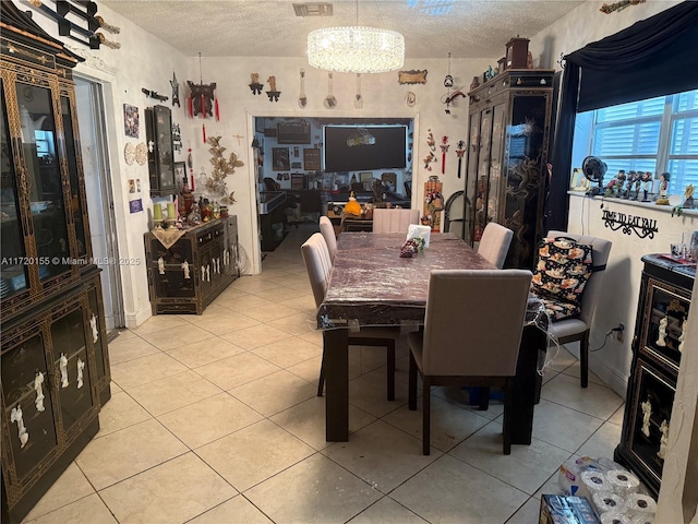 dining room with light tile patterned floors, a textured ceiling, and a notable chandelier