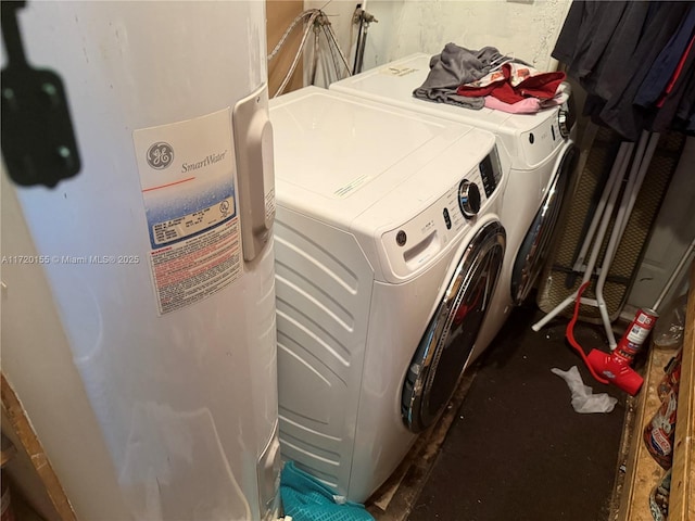 laundry area featuring electric water heater and separate washer and dryer