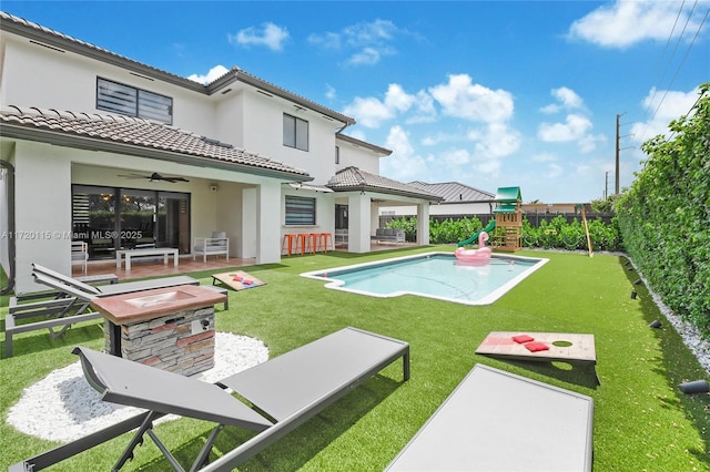 view of swimming pool featuring a playground, a patio area, ceiling fan, and a lawn