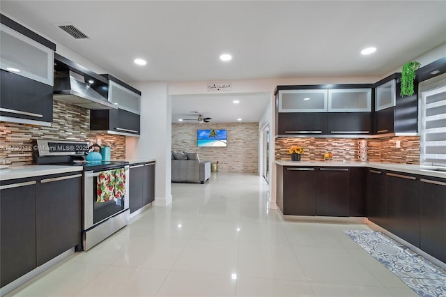 kitchen featuring light tile patterned floors, backsplash, stainless steel electric stove, and wall chimney exhaust hood