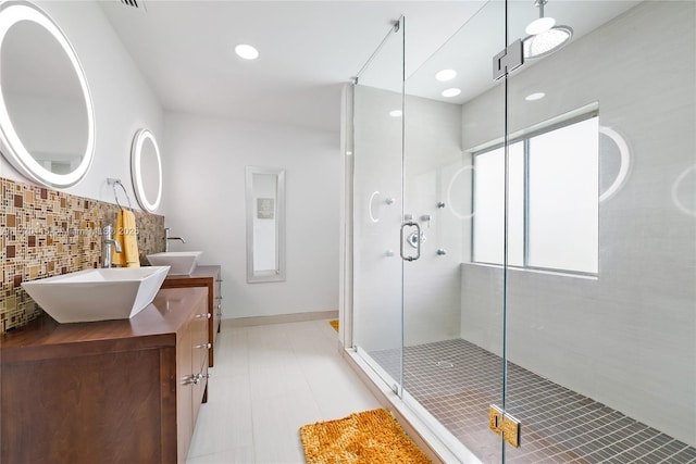 bathroom with vanity, backsplash, and walk in shower