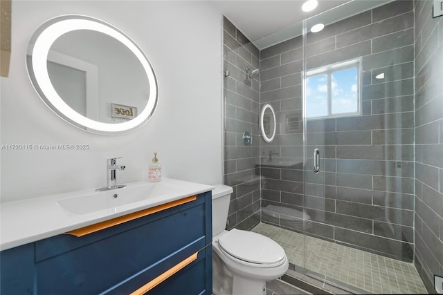 bathroom featuring vanity, an enclosed shower, and toilet