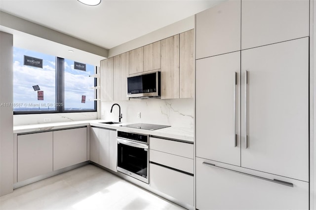 kitchen featuring backsplash, sink, and appliances with stainless steel finishes