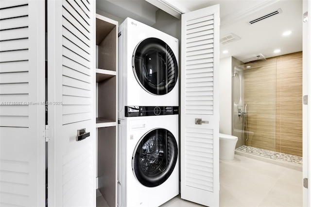 clothes washing area featuring stacked washer and clothes dryer