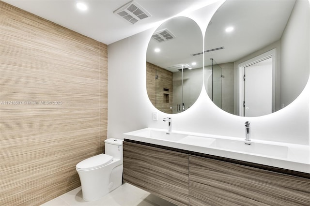 bathroom featuring vanity, a shower with shower door, and toilet