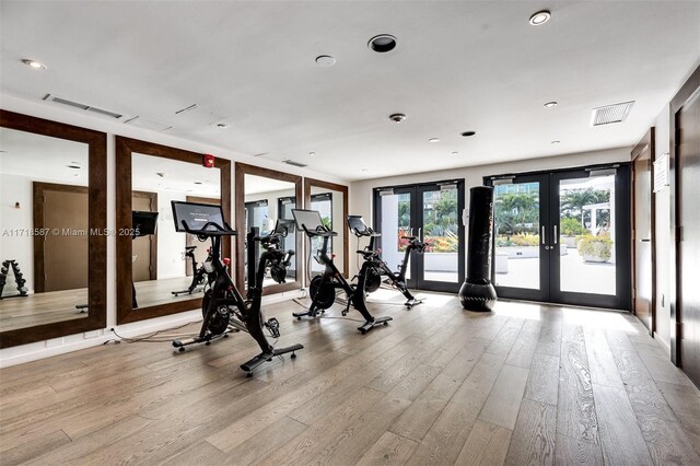 exercise room with french doors and light wood-type flooring