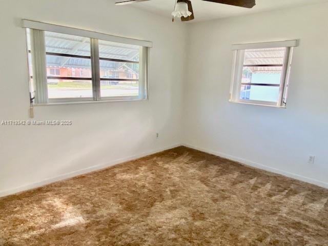 carpeted empty room featuring a healthy amount of sunlight and ceiling fan