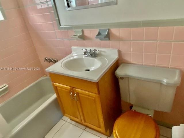 bathroom with tile patterned flooring, vanity, and tile walls