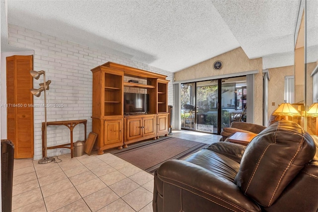 living room with a textured ceiling, light tile patterned flooring, brick wall, and vaulted ceiling