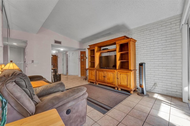 tiled living room with a textured ceiling, brick wall, and lofted ceiling