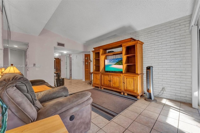 living room with a textured ceiling, light tile patterned flooring, brick wall, and vaulted ceiling