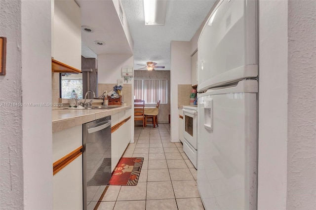 kitchen featuring white appliances, white cabinetry, ceiling fan, and plenty of natural light