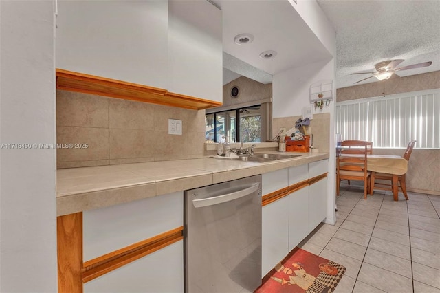 kitchen with a textured ceiling, ceiling fan, sink, dishwasher, and white cabinetry