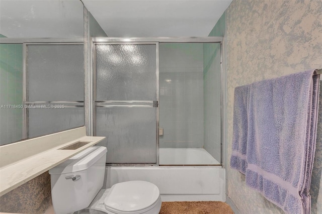 bathroom with toilet and bath / shower combo with glass door