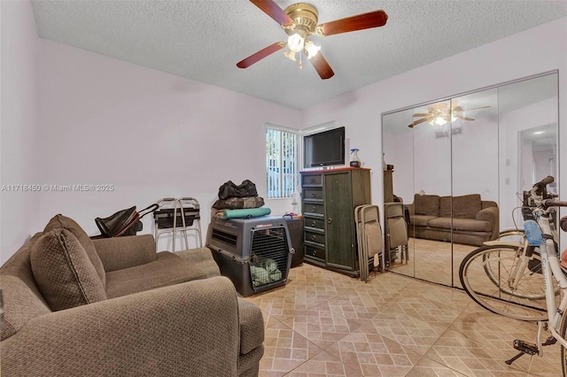 living room featuring a textured ceiling and ceiling fan