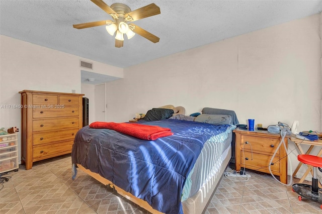 bedroom featuring ceiling fan and a textured ceiling