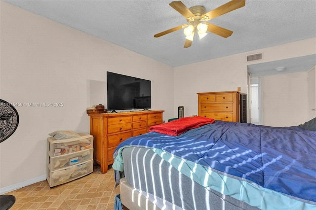 bedroom with ceiling fan and a textured ceiling