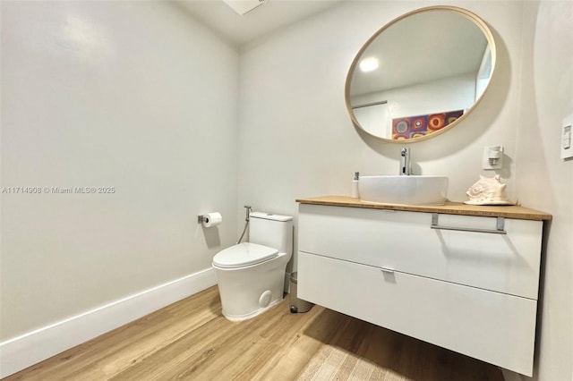 bathroom with vanity, wood-type flooring, and toilet
