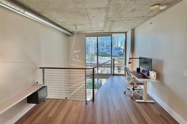 unfurnished office featuring wood-type flooring and expansive windows