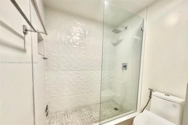 bathroom featuring toilet and a shower with door
