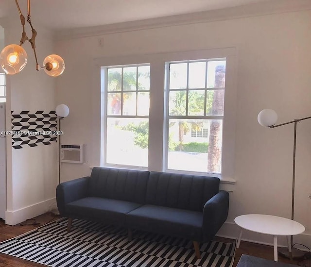 living room featuring a wall unit AC, crown molding, and a wealth of natural light