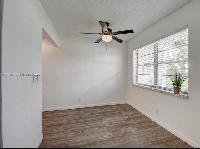 spare room featuring ceiling fan, wood-type flooring, and a textured ceiling