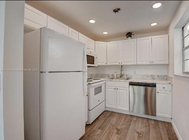 kitchen with white cabinets, white appliances, light hardwood / wood-style flooring, and sink