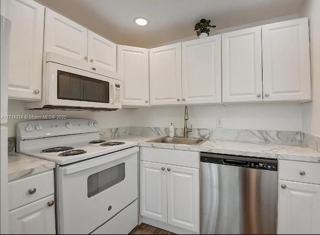 kitchen featuring light stone countertops, white appliances, white cabinetry, and sink