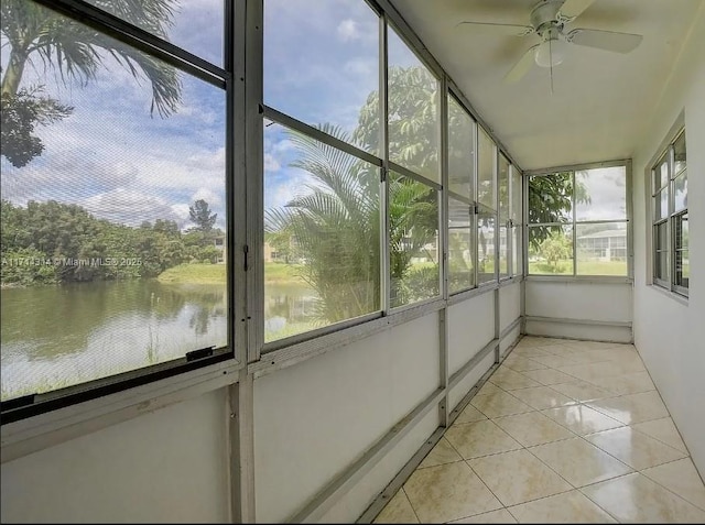 unfurnished sunroom with a water view and ceiling fan