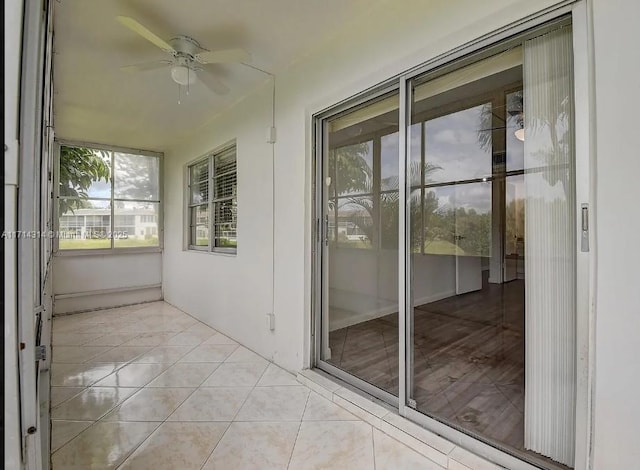 unfurnished sunroom with ceiling fan