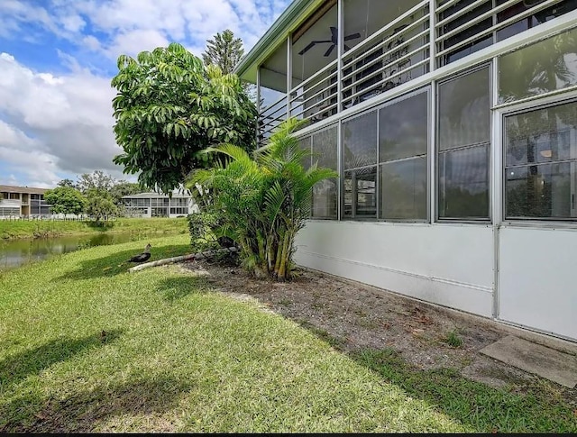 view of property exterior with a yard and a water view