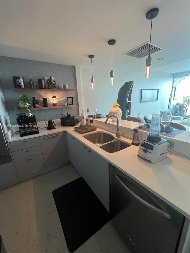 kitchen featuring dishwasher, gray cabinets, kitchen peninsula, pendant lighting, and sink