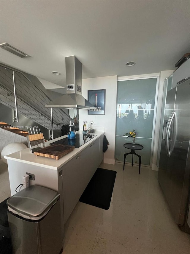 kitchen featuring black electric stovetop, stainless steel fridge with ice dispenser, and island exhaust hood