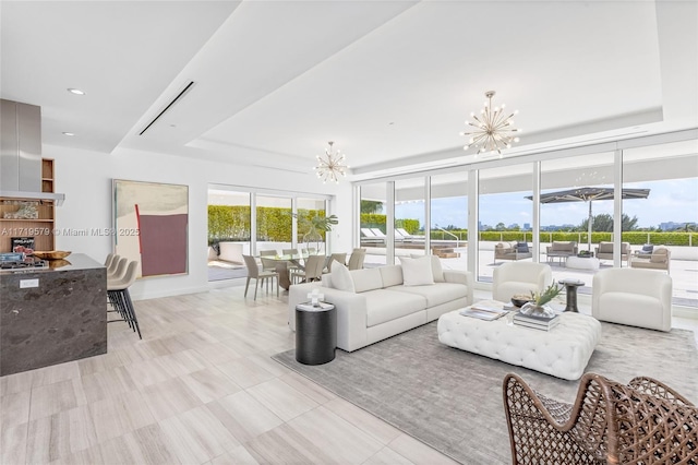 living room featuring a tray ceiling and a chandelier