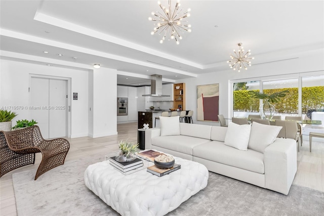 living room featuring a chandelier and a raised ceiling