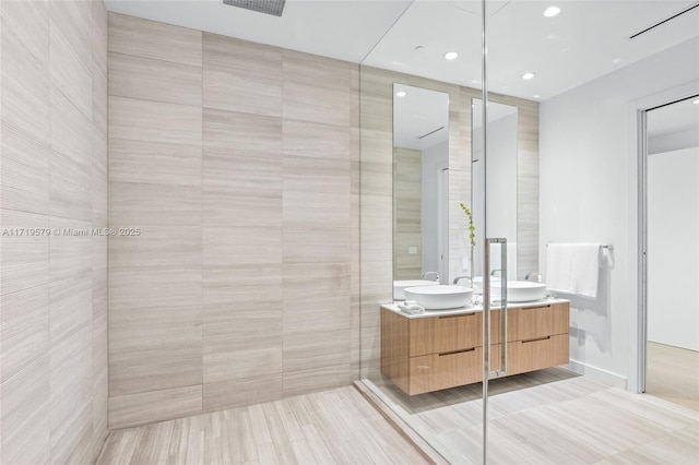 bathroom featuring vanity and tile walls