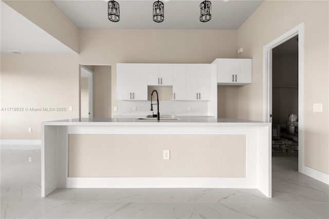 kitchen with white cabinets and a kitchen island with sink