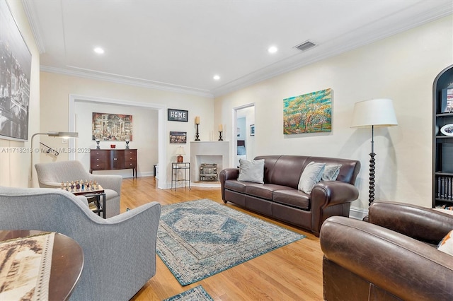 living room with crown molding and light hardwood / wood-style floors