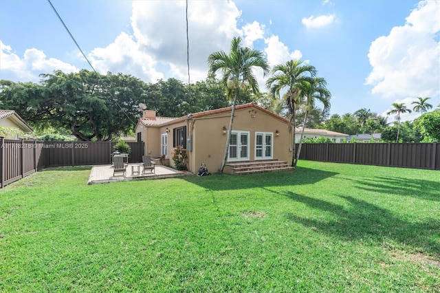 back of house with a lawn and a patio